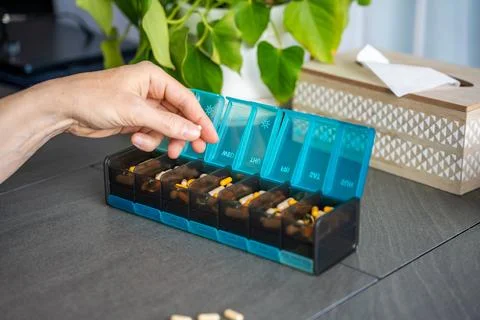 Weekly pill organizer with labeled compartments for daily medication doses Stock Photos