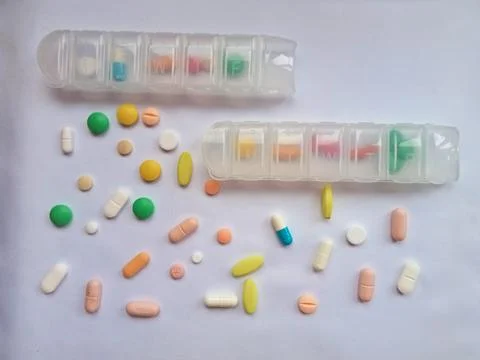 Weekly Pill Organizers with Assorted Tablets on White Background  Medication Stock Photos