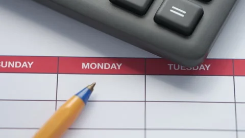 A weekly schedule with a ballpoint pen and a calculator lying on it. Stock Footage 307068574