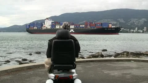 Weel Chair Viewer Of Passing Container Ship Stock Footage 12582696
