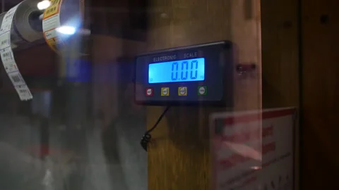 Weighing a parcel package on electronic scales at a post office Stock Footage 172540069