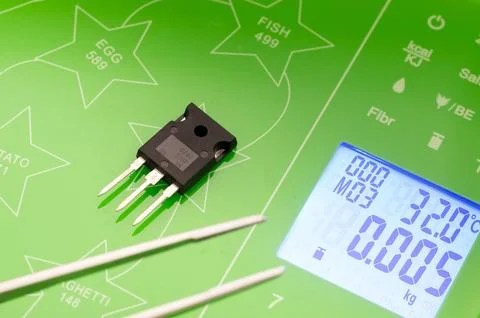 Weighing a transistor on a scale Fotos de archivo