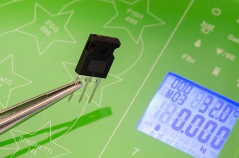 Weighing a transistor on a scale Foto stock