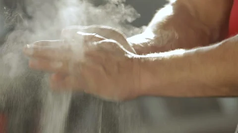 Weight lifter bodybuilder smears his hands with magnesium. Stock-Footage 87952065