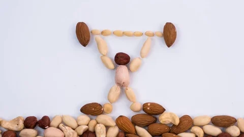Weight Lifter made of nuts raises the bar. Stop motion Stock Footage 72683962