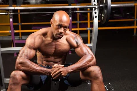 Weight lifter sitting at the bench press about to lift a barbell. Stock Photos