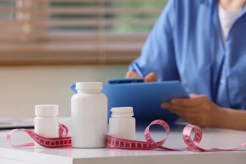 Weight loss and diet planning with supplements and measuring tape on a table, Stock Photos