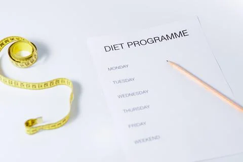 Weight loss concept with diet programme and tape measure over white. Includes Stock-Fotos