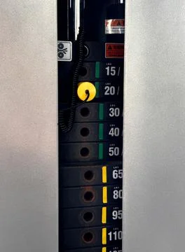 Weight stack machine with yellow selector pin in gym Stock Photos