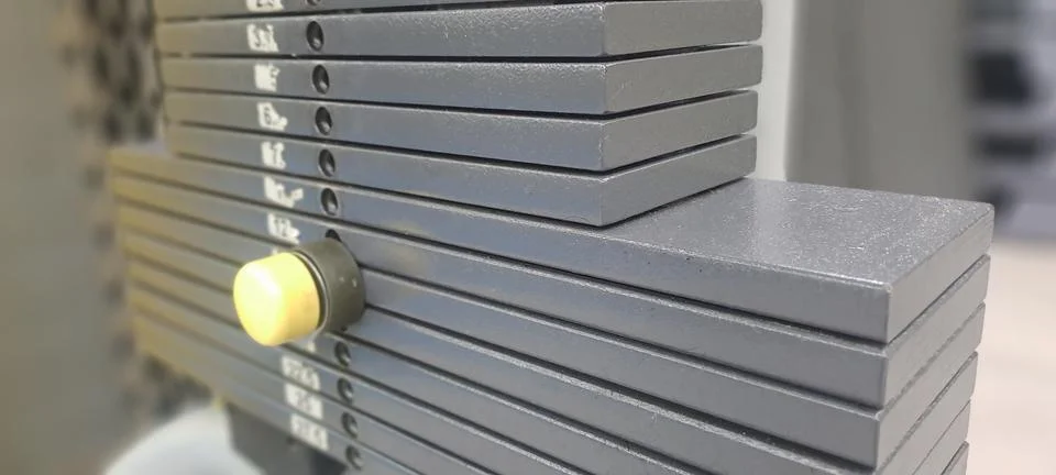 Weight stack pin selecting weight on exercise machine in gym Stock Photos