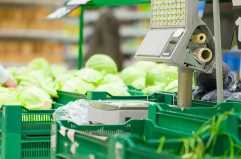 Weighting machine among boxes with vegetables in supermarket Stock Photos