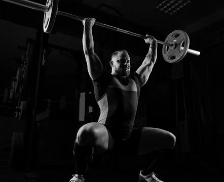 Weightlifter does an exercise with a barbell. Stock Photos
