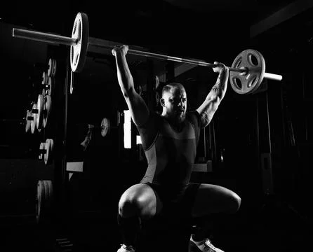 Weightlifter does an exercise with a barbell. Stock Photos
