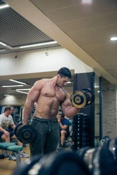 The weightlifter does exercise in a gym Stock Photos