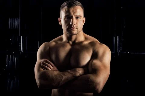 The weightlifter is posing in front of the camera with his arms crossed ove.. Stock Photos
