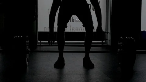 The weightlifter stands with his hands behind the heavy barbell. Stock Footage 117632011