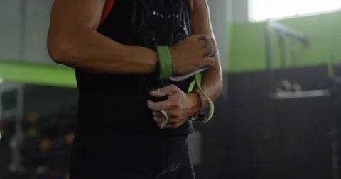 Weightlifter tying exercise bands around her wrists Stock Footage 96891887