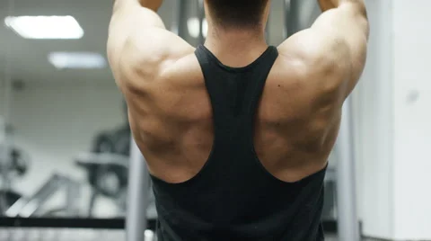 Weightlifter's back as he lifts weights from a machine, in slow motion Stock Footage 59865249