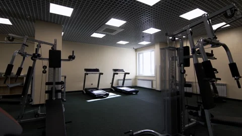 Weightlifting systems and treadmills in spacious gym hall Видео 283383574
