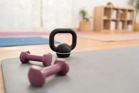 Weights and kettlebell on exercise mat in gym during morning workout session Stock Photos