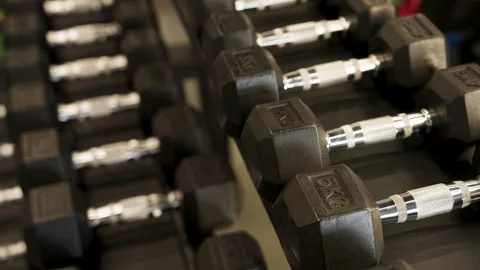 Weights arranged on a shelf in a gym for exercise and strength training sessions 스톡 동영상 345030430