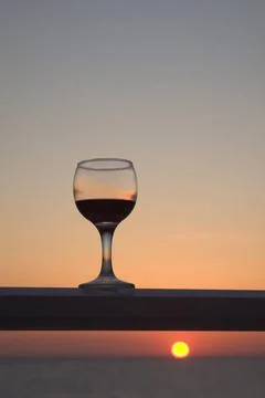 Wein-Genuss an einem Sommerabend Rotweinglas vor Sonnenuntergang Copyright... Stock Photos