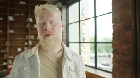 Weird hipster guy lost touch with the outside world and deep into techno music Stock Footage 255110964