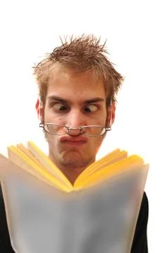 Weird nerd reading a book with glasses crossed eyed Stock Photos