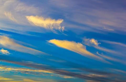 Weird shaped yellow clouds at dusk Stock Photos