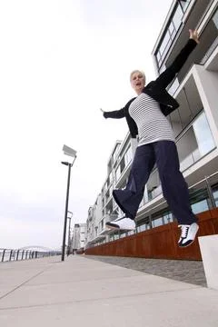 Weißhaarige Frau über 50 springt in die Luft attraktive weisshaarige Frau . Stock Photos