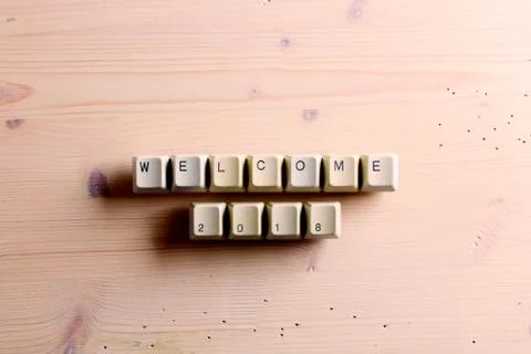 Welcome 2018 New Year on computer keyboard keys buttons on a wooden background Foto stock