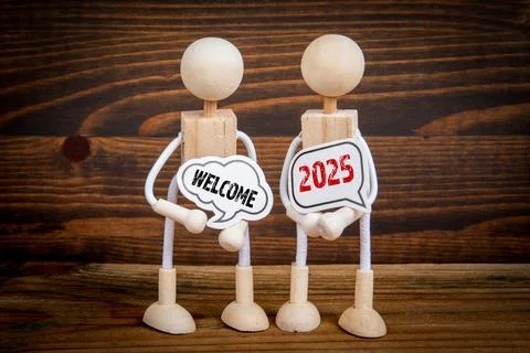 Welcome 2025 Concept. Two speech bubbles and miniature people on a wooden Stock Photos