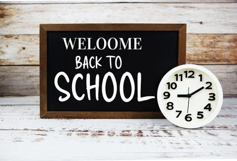 Welcome Back to School text message write on chalkboard with white clock on.. Stock Photos