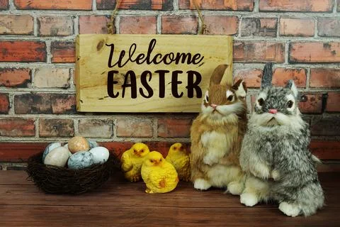 Welcome Easter text with Easter eggs with rabbit doll and wooden signboard .. Stock Photos