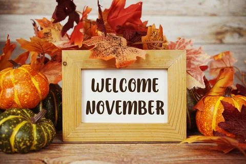 Welcome November text with maple leaf decoration on wooden background Stock Photos
