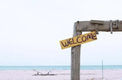 Welcome sign on an empty beach with simplified background isolated Stock Photos