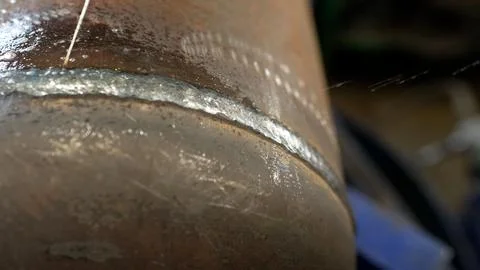 Welder applying water to cool down metal pipe. Stock Photos