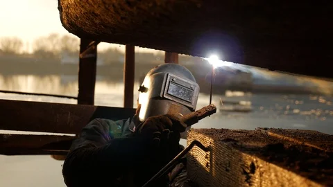 Welder are working under the barge at the bank of the river. Video stock 87506523