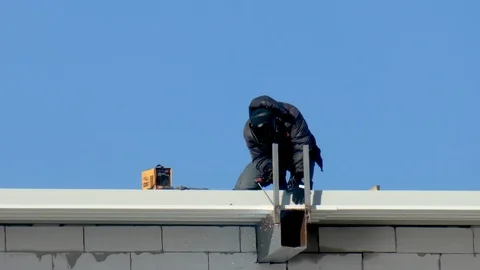 Welder on a building against the sky Stock Footage 105366373