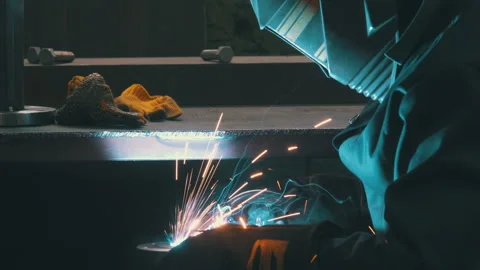 Welder Close-Up Wearing Mask with Bright Sparks Flying | Metal Flange Welding Stock Footage 343806471