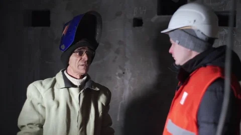 Welder communicates with a young guy Stock Footage 82294585