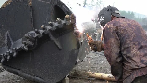 Welder in the forest is repairing a drill. Welding 4K Stock Footage 236405504