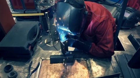 Welder is going welding of the metal profile. Sparks are flying around Stock Footage 71647636