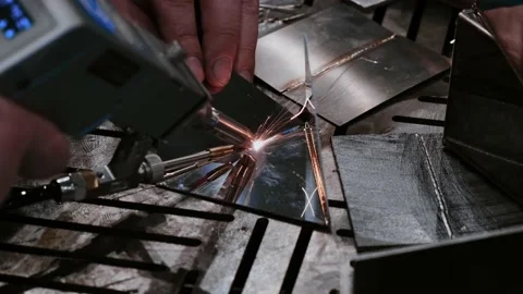 Welder hands using portable handheld laser welding machine with sparks close up Stock Footage 181449731
