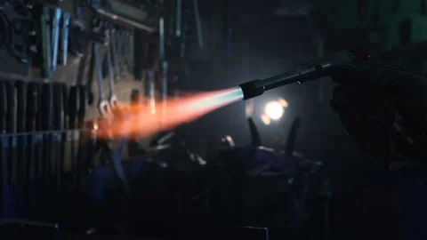 Welder holding torch with flame and working with metal repair part. Gimbal shot. Stock Footage 124045929