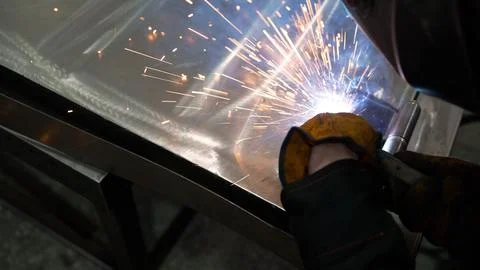 Welder joining metal components with electrode, creating sparks Stock Photos