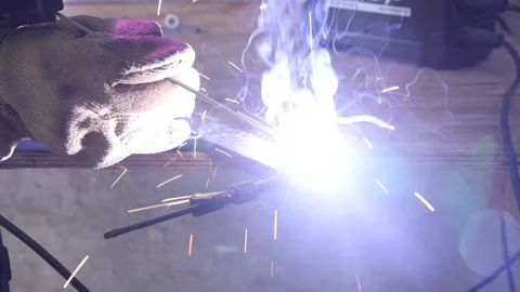 Welder joining metal pieces generating bright sparks Видео 310948936