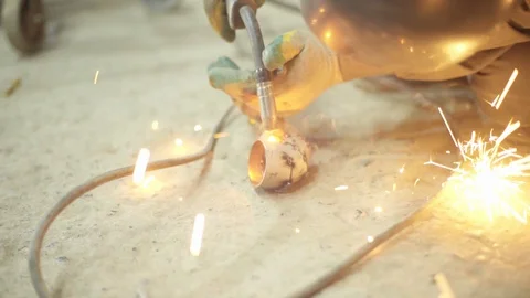 Welder joining pieces of pipe together making custom exhaust Stock Footage 128920464