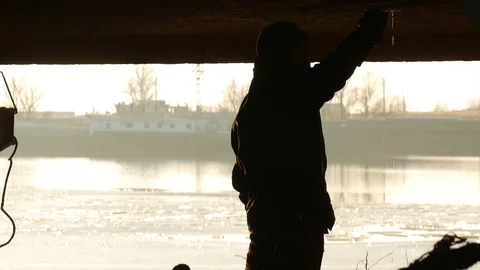 The welder kneels and knocks on the hull, water drips from the hole Video stock 87506107