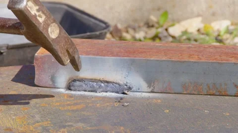The welder knocks down slag from the surface with a hammer Stock Footage 181543129